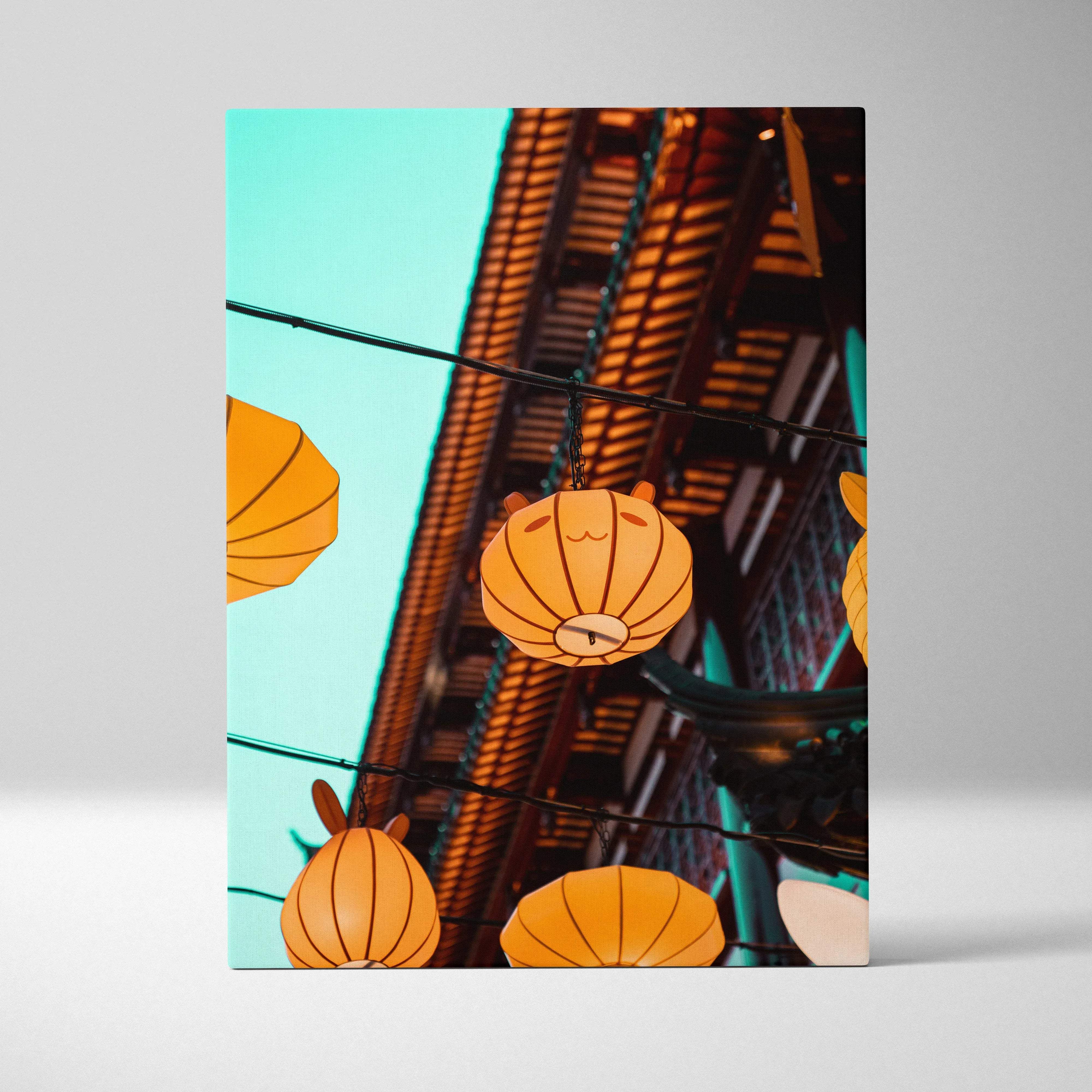 Orange cartoon paper lanterns with cute faces hang over historic wood architecture in warm turquoise sky canvas wall art