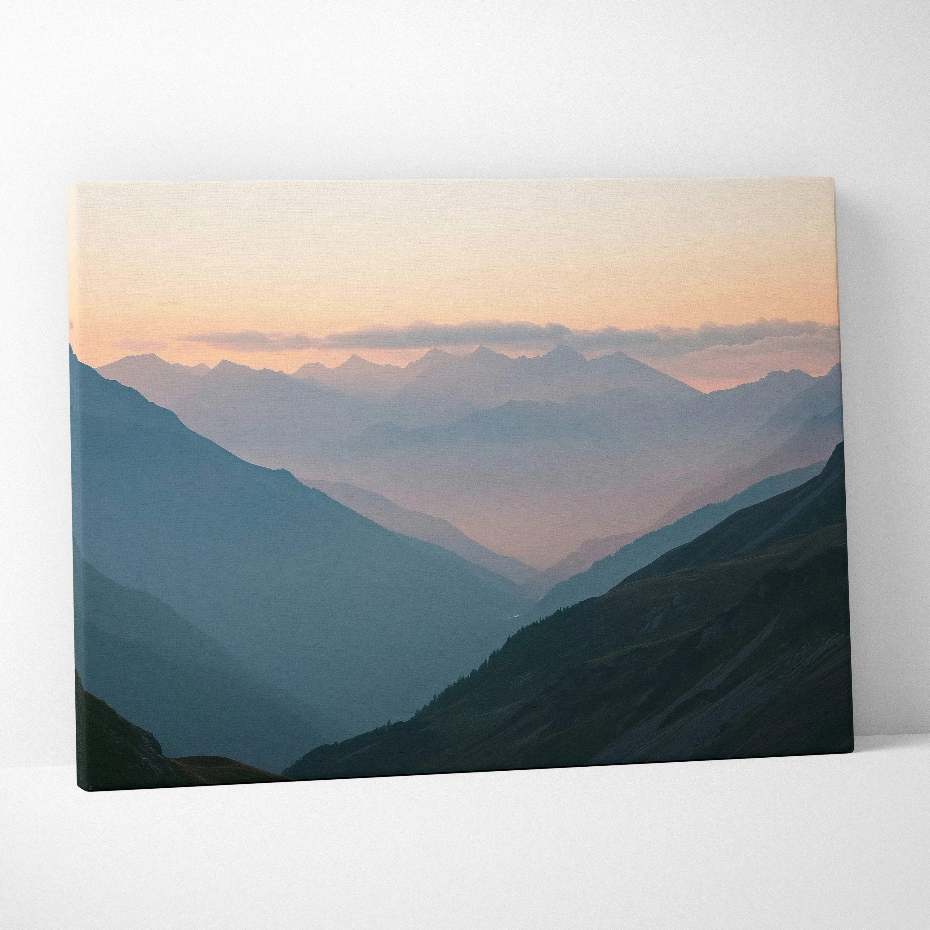 Atmospheric misty mountain valleys canvas print at dawn in muted blues and peach sky