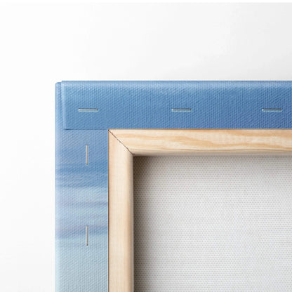 Close-up of blue sky canvas stretched on wooden frame showing corner stapling for wall art print.