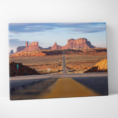 Desert landscape canvas wall art featuring a long road leading to red rock formations under a blue sky.