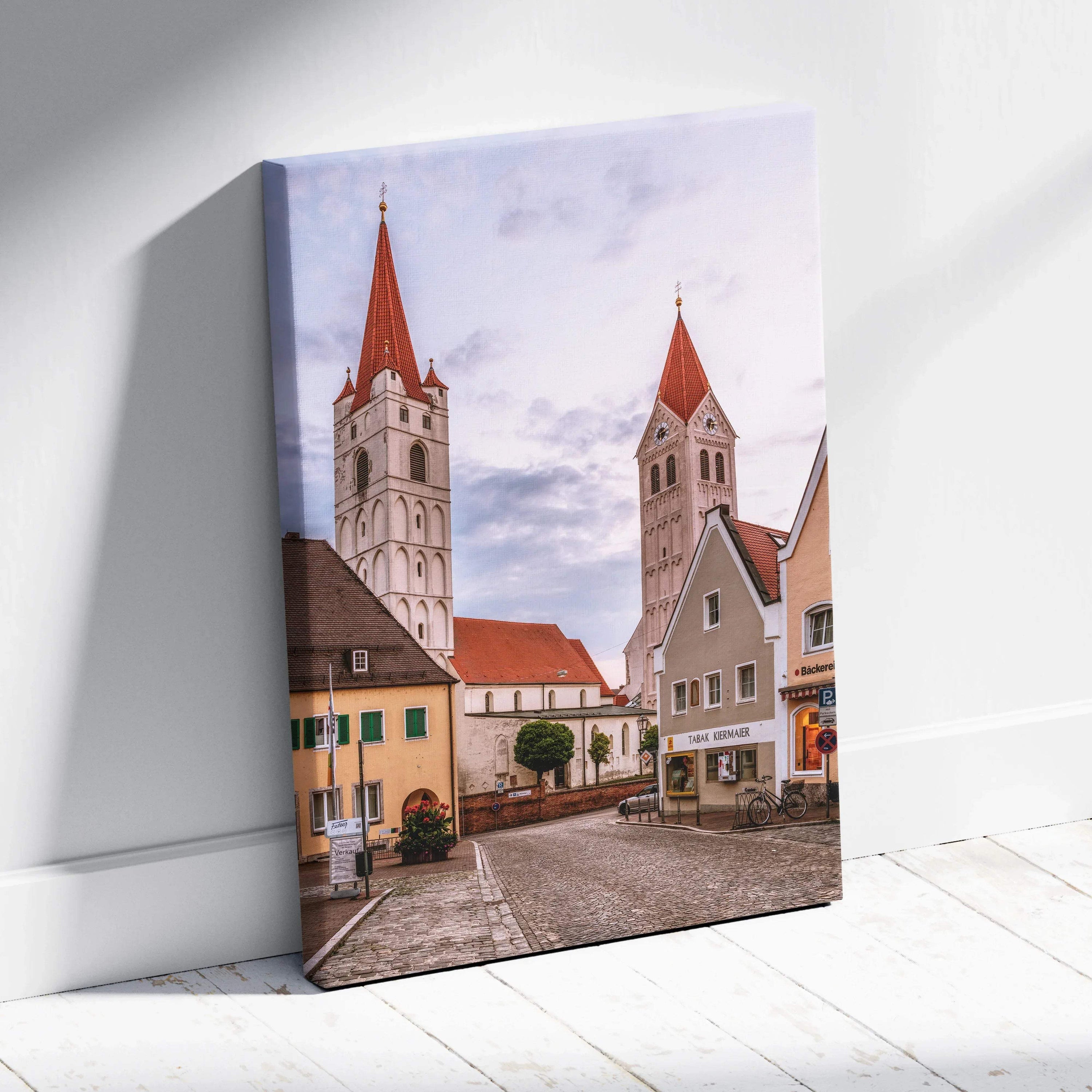 Canvas wall art featuring a quiet urban street with tall church steeples and traditional buildings under a soft sky.