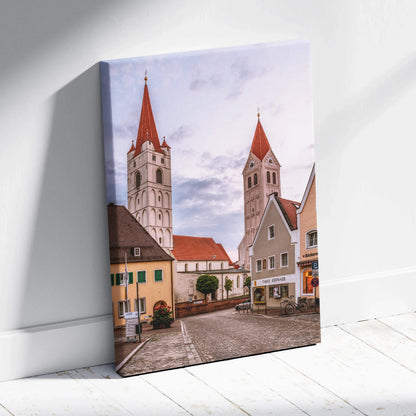 Canvas wall art featuring a quiet urban street with tall church steeples and traditional buildings under a soft sky.