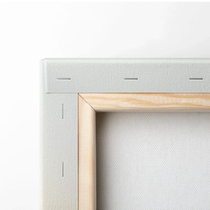 Close-up of wooden frame corner and white stretched canvas for wall art display.