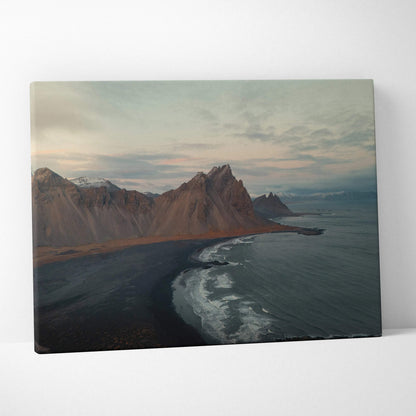 Majestic mountain range meeting the ocean on canvas wall art with moody sky tones.