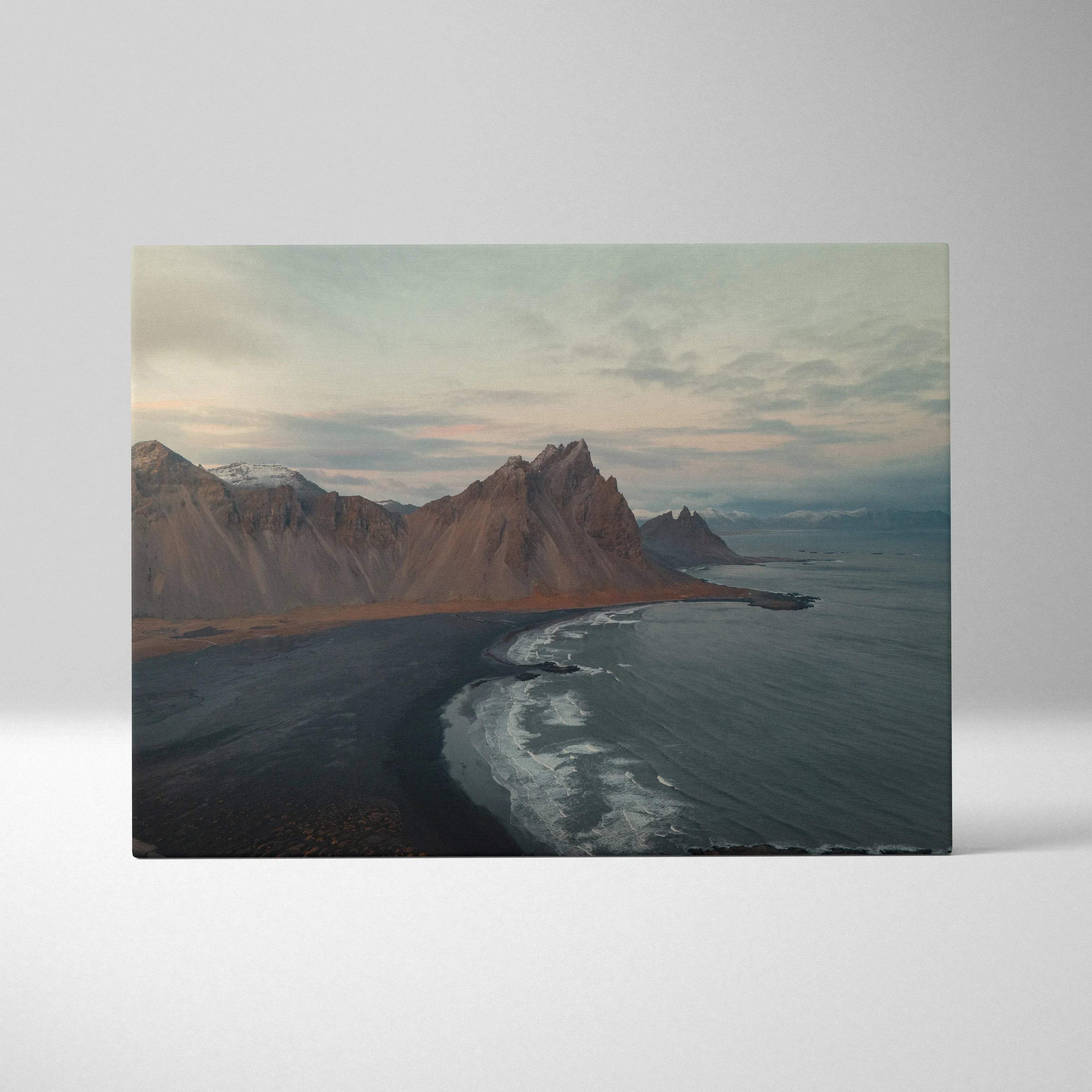 Canvas wall art featuring dramatic mountains and serene beach under a cloudy sky.