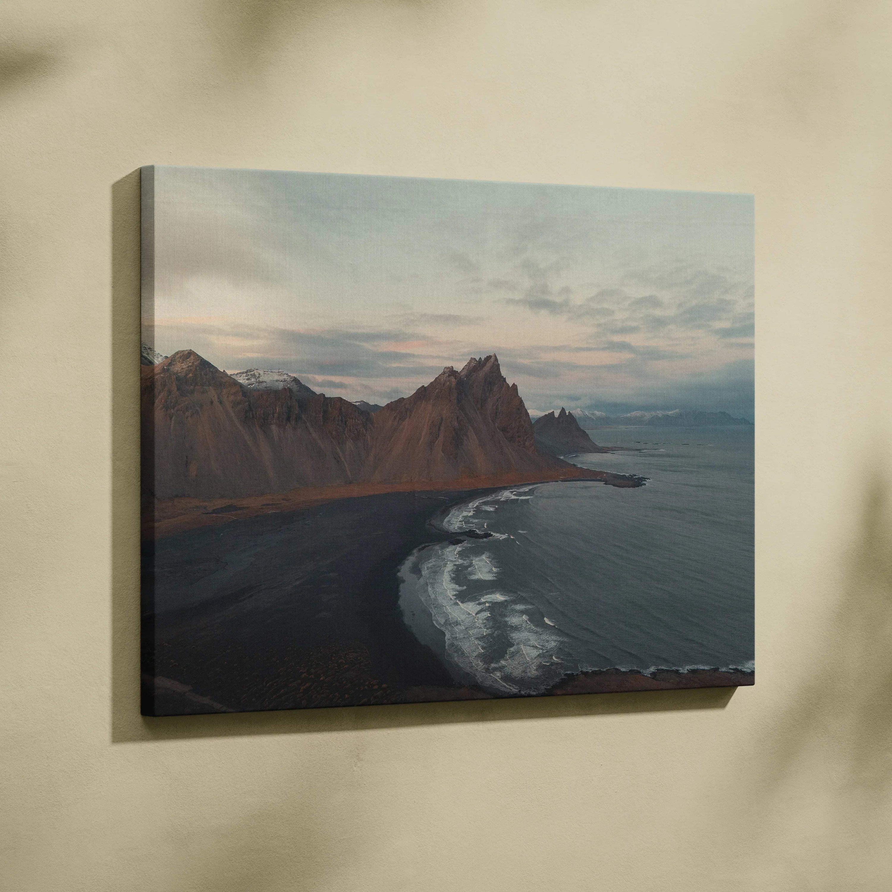 Canvas wall art featuring majestic mountains beside a black sand beach under a cloudy sky.