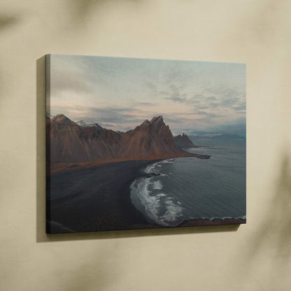 Canvas wall art featuring majestic mountains beside a black sand beach under a cloudy sky.