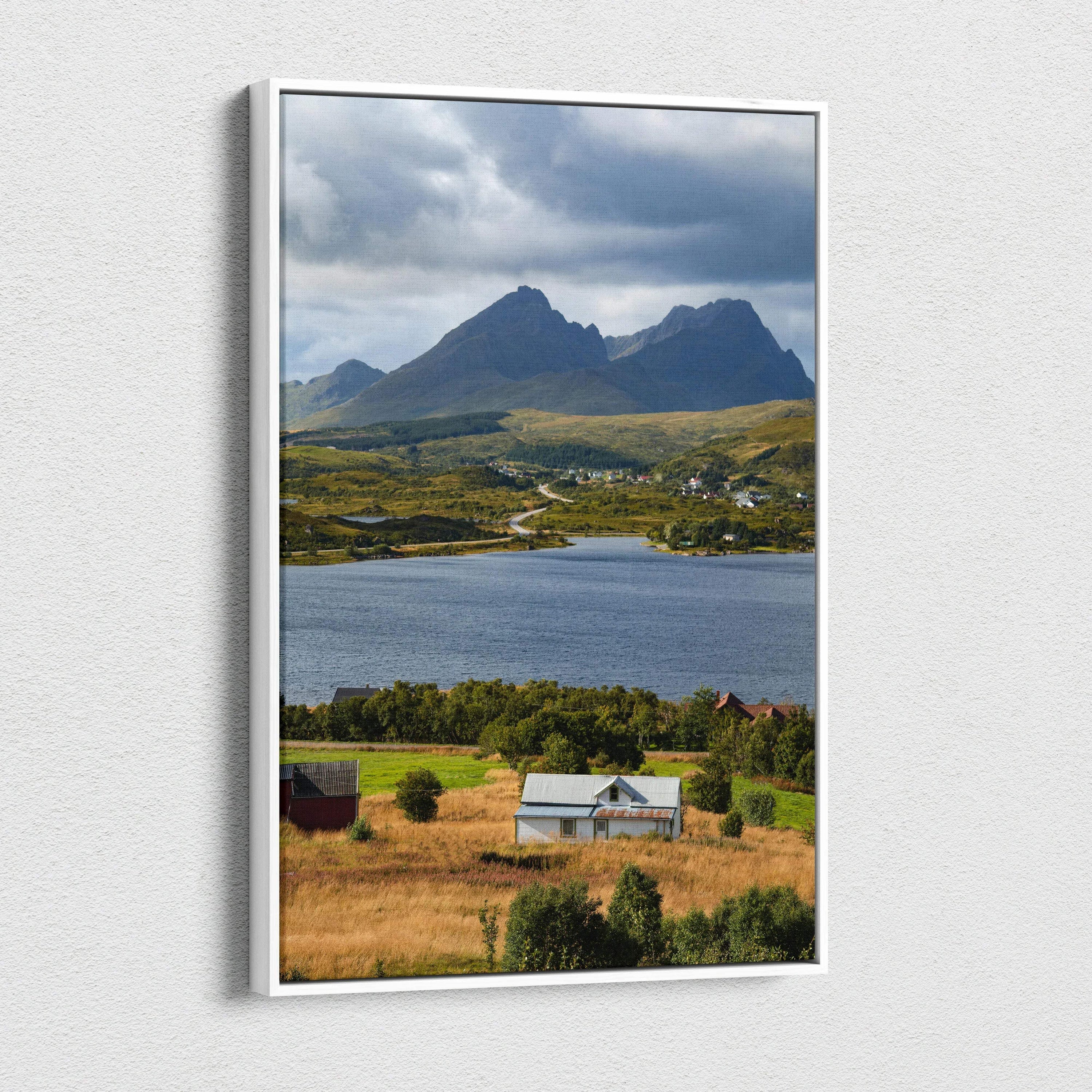 Vertical canvas wall art featuring majestic mountains over a lake with a rural farmhouse foreground.