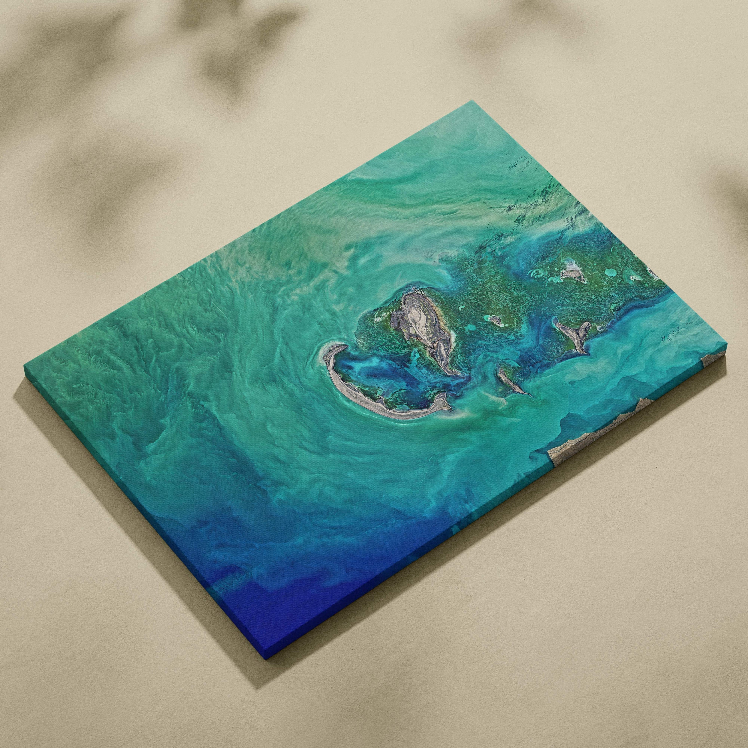 A rectangular canvas print featuring a swirling abstract ocean scene in deep blues teal and green for coastal decor