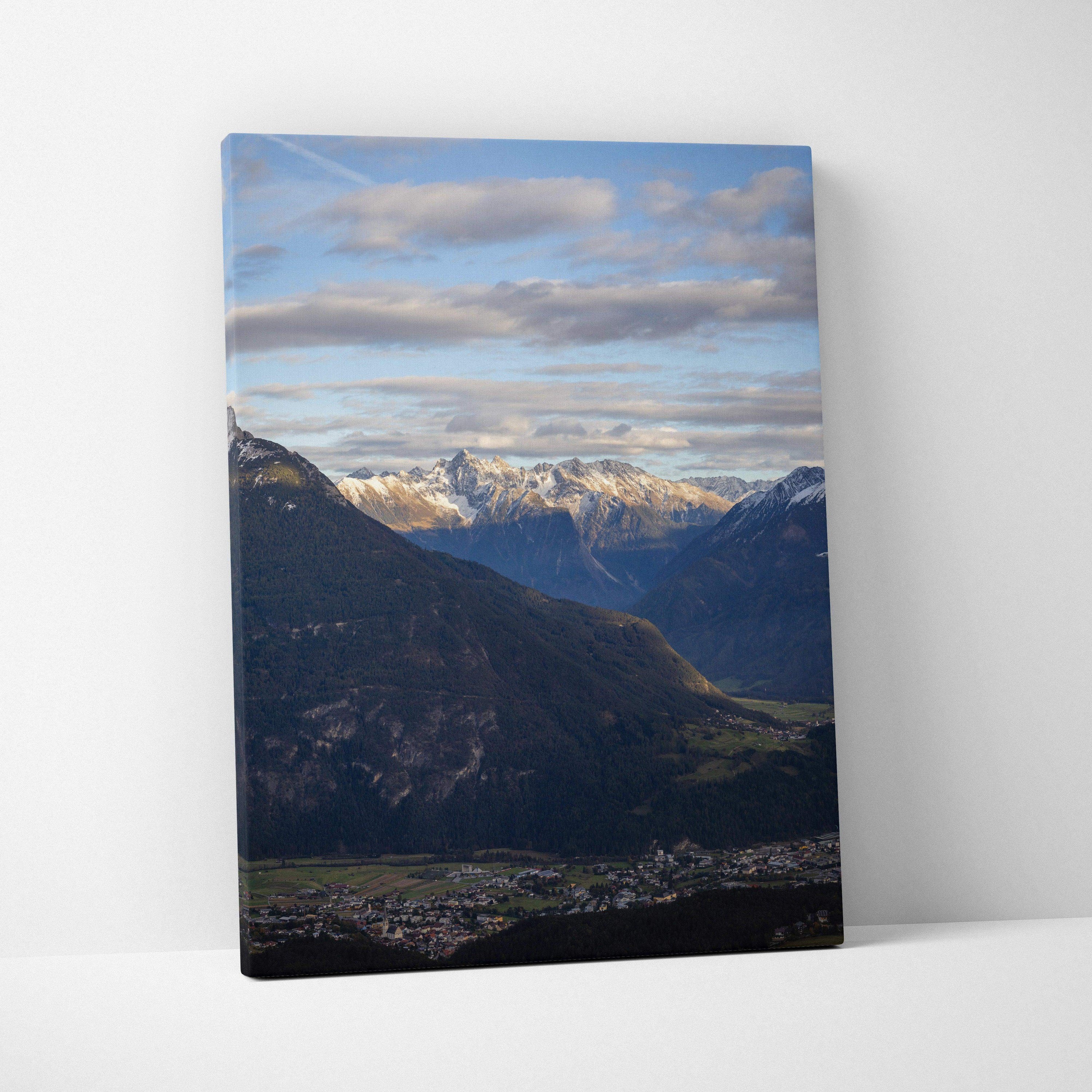 Vertical canvas wall art featuring majestic mountain landscape under a bright blue sky with scattered clouds.