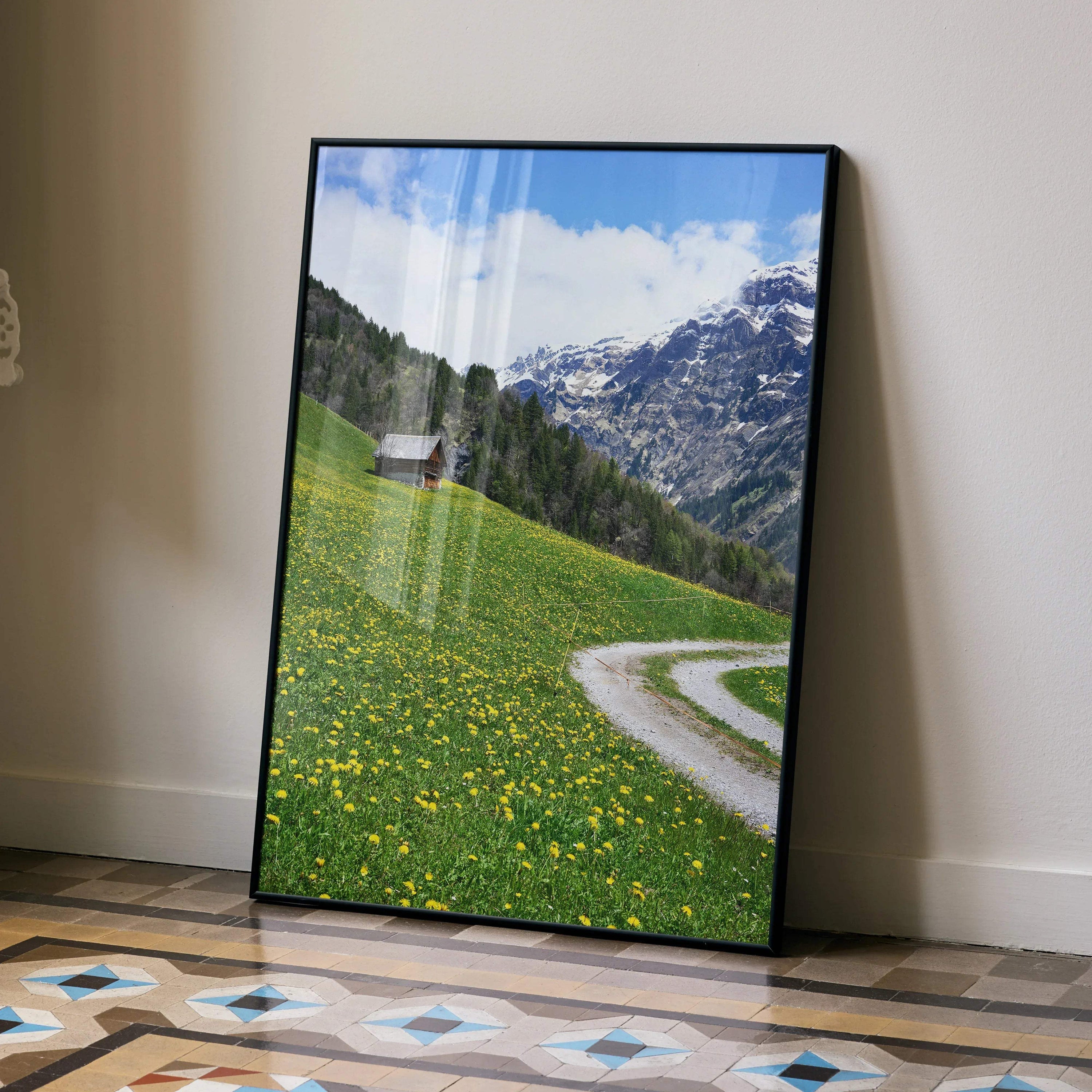 Vertical mountain landscape poster with green meadow, wildflowers, winding dirt path, and blue sky wall art.