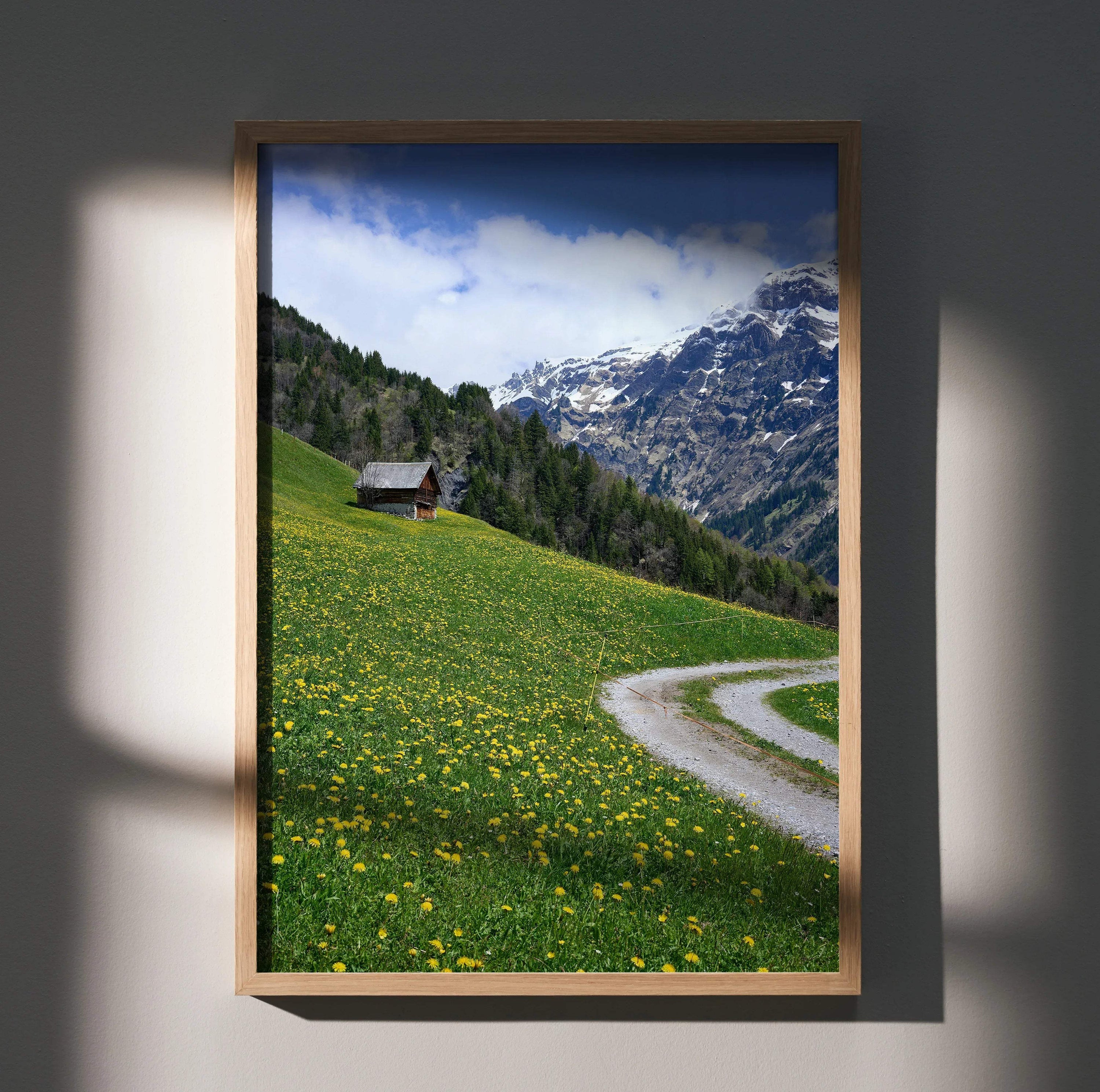 Vertical poster wall art featuring a winding path through a yellow wildflower meadow with forest and snow-capped mountains.