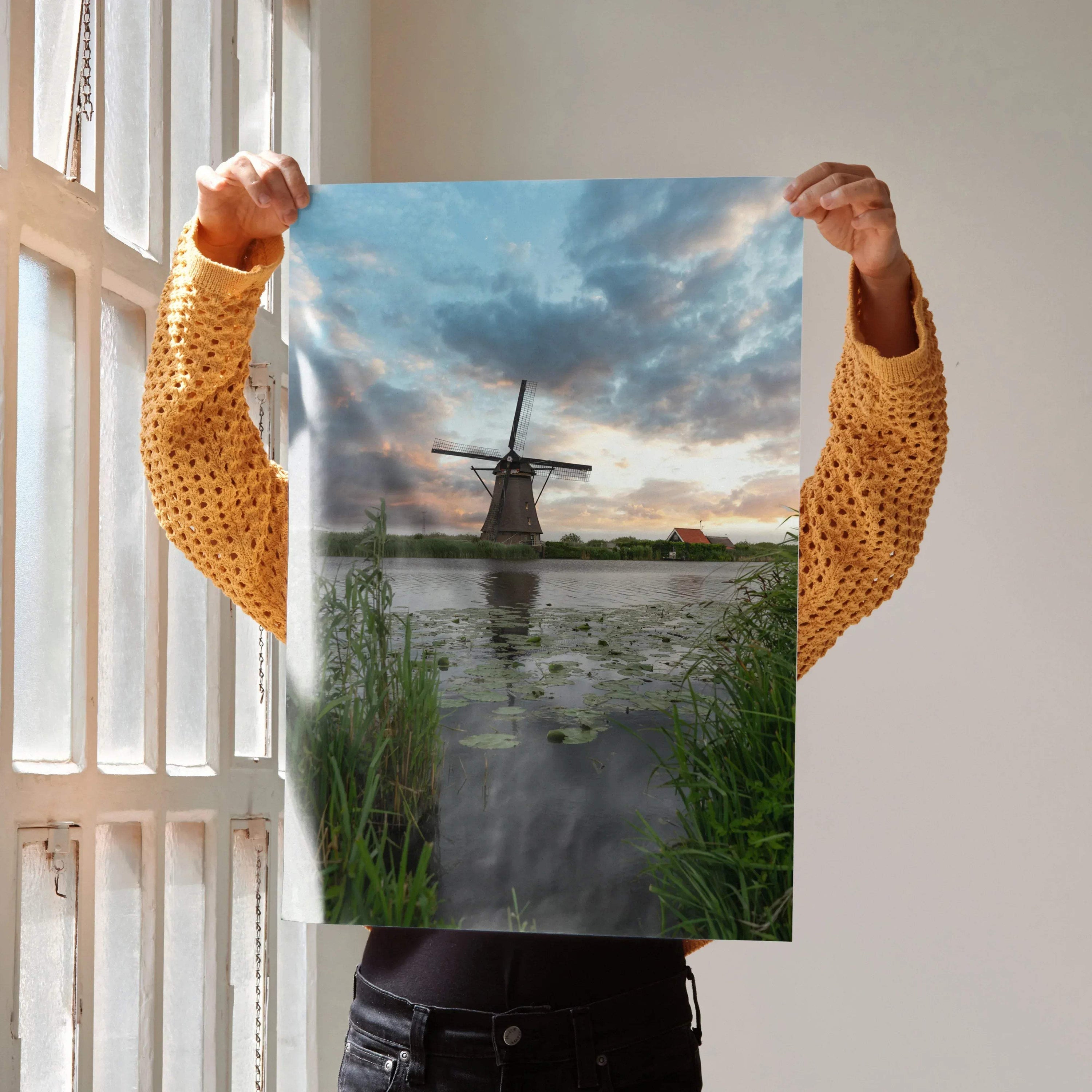 Vibrant sunset poster featuring a windmill over a pond with lush greenery, vertical wall art.