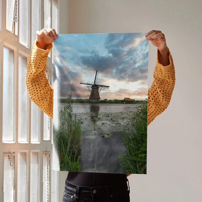 Vibrant sunset poster featuring a windmill over a pond with lush greenery, vertical wall art.