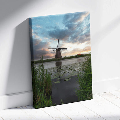 Canvas wall art featuring a windmill at sunset with dramatic clouds and reflective water.