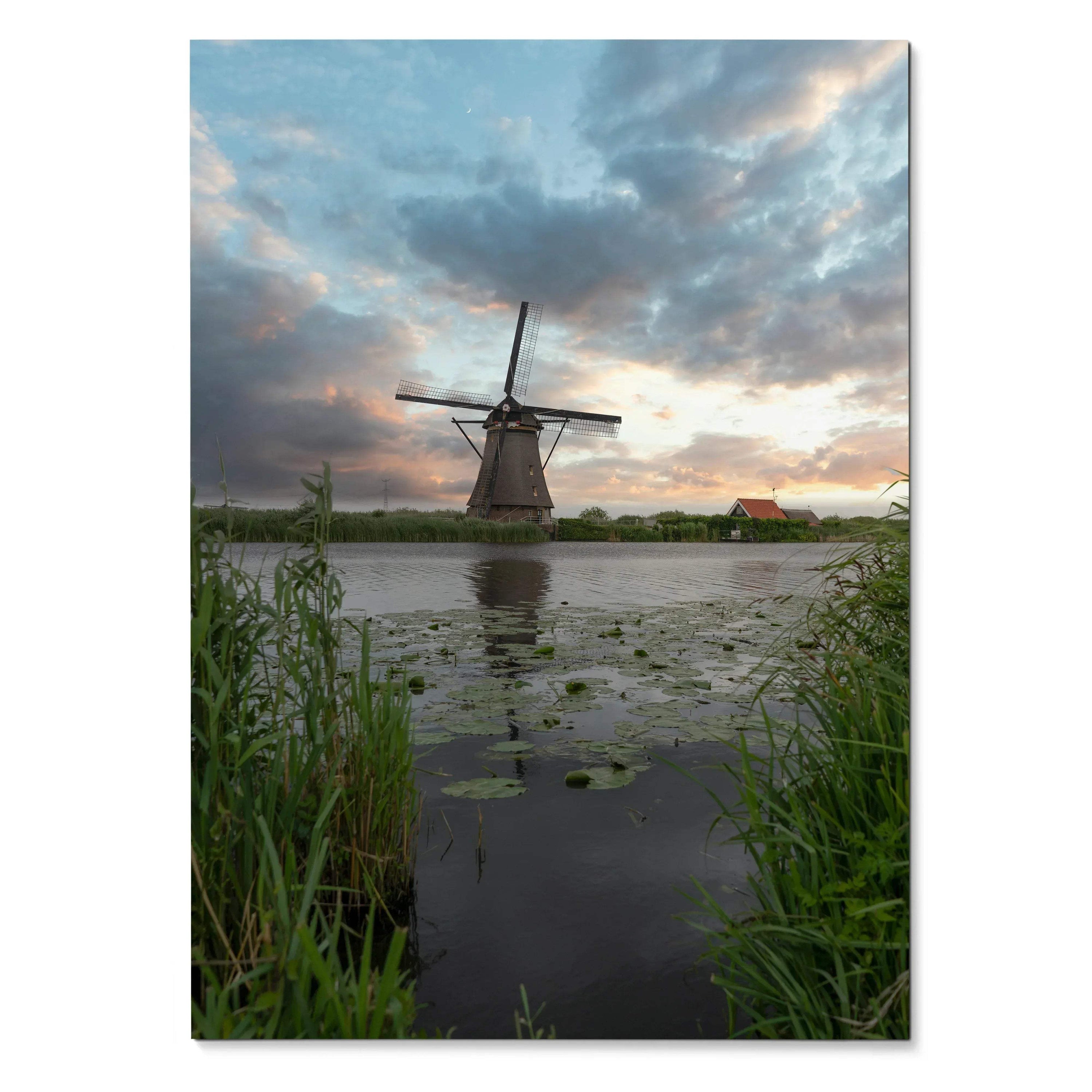 Vertical poster of a windmill at sunset with dramatic clouds and reflective water, vibrant wall art.
