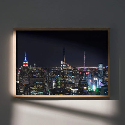 City night skyline wall art poster with illuminated skyscrapers and dark sky in wooden frame.