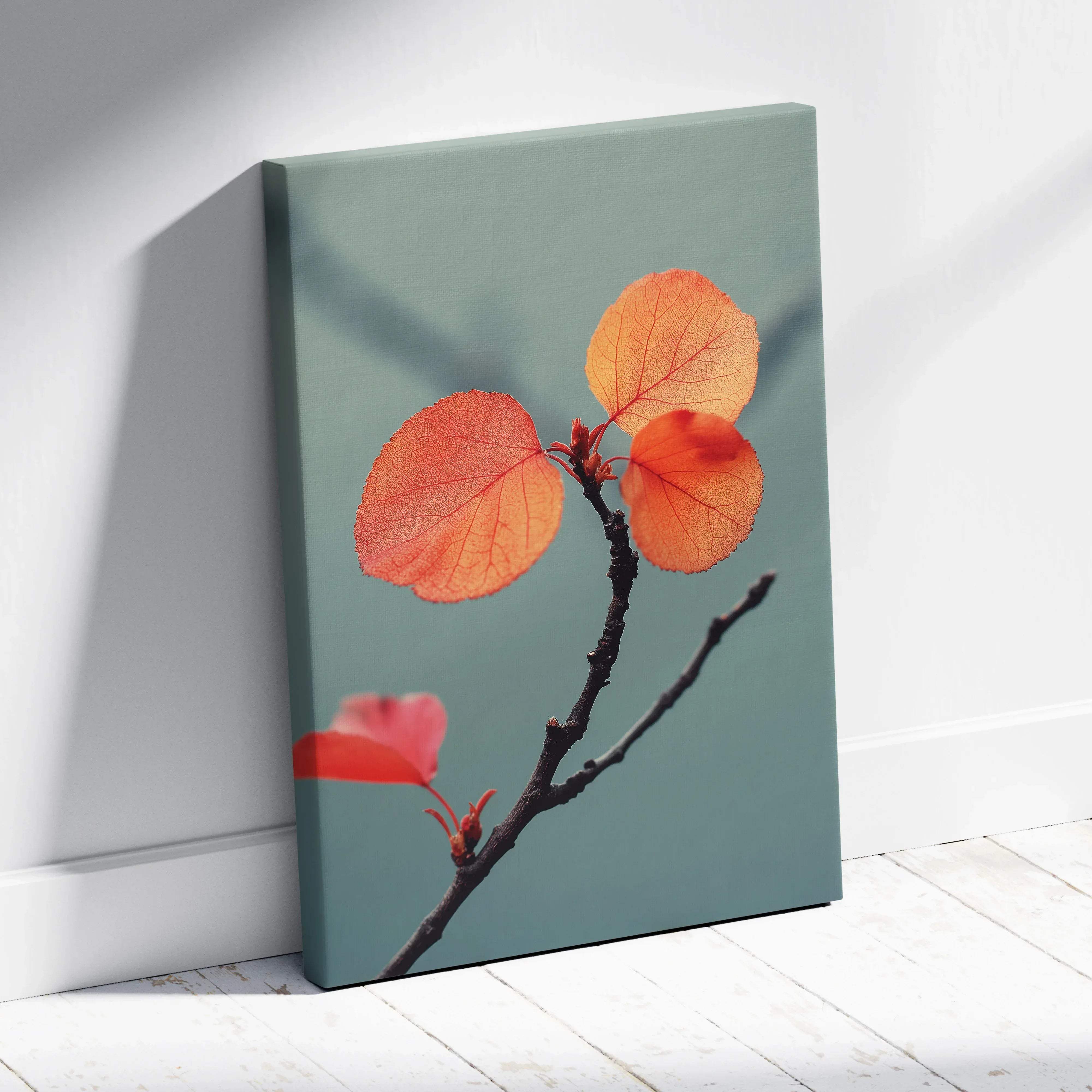 A framed canvas print of a branch with vibrant orange and red leaves on a muted teal background for autumn decor