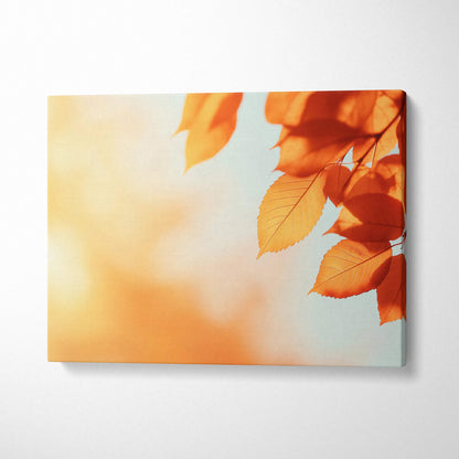 Canvas wall art featuring vibrant orange autumn leaves against a soft blue and warm glowing background.