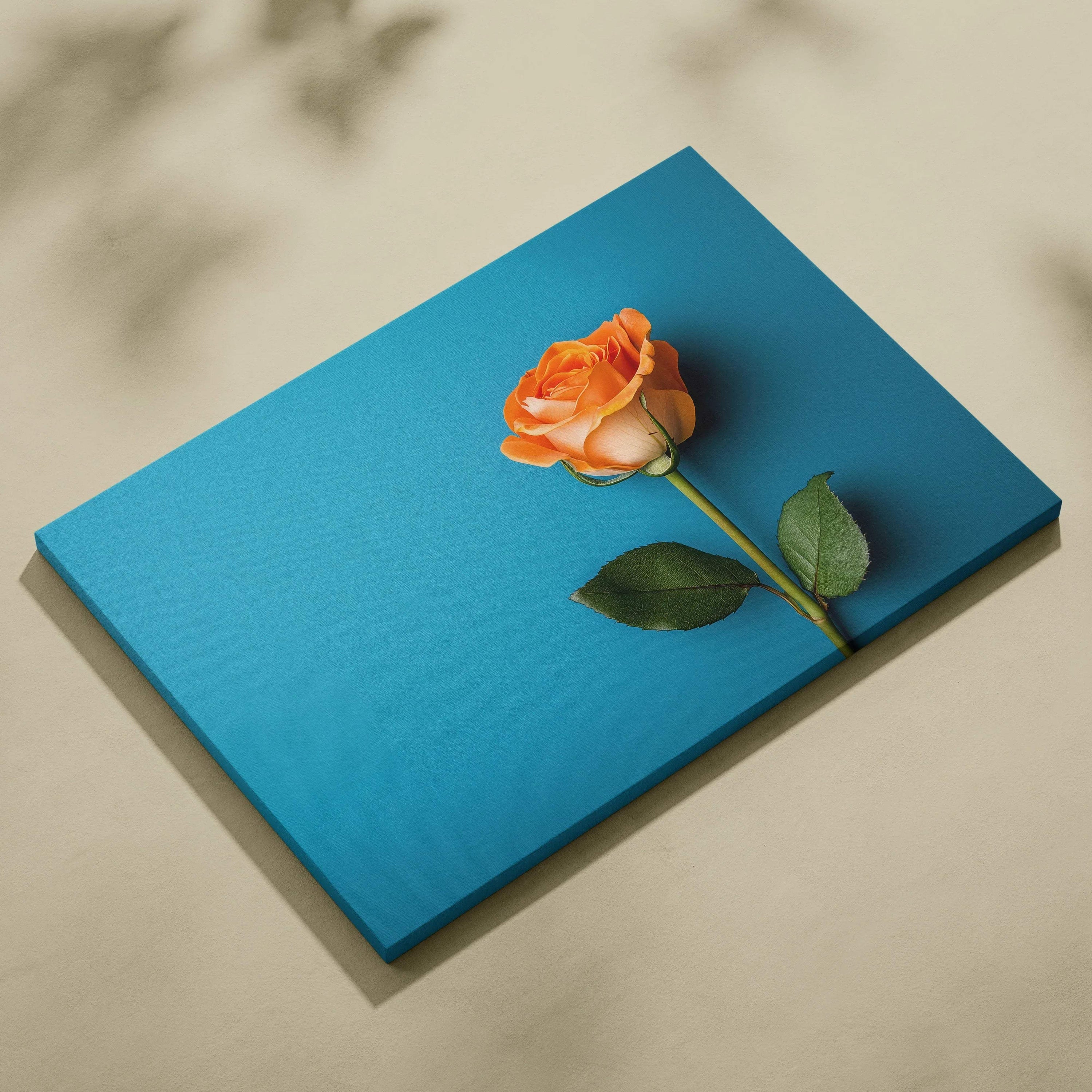 Canvas wall art featuring a single orange rose on a vibrant blue background.