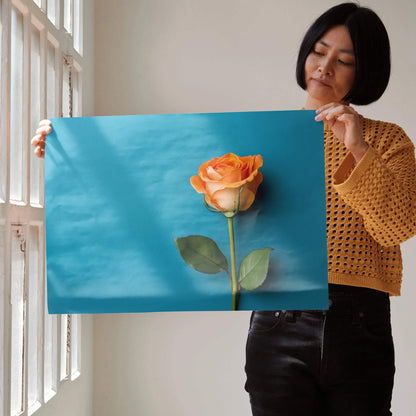 Vibrant floral poster with detailed orange rose against a bright blue background, modern wall art.