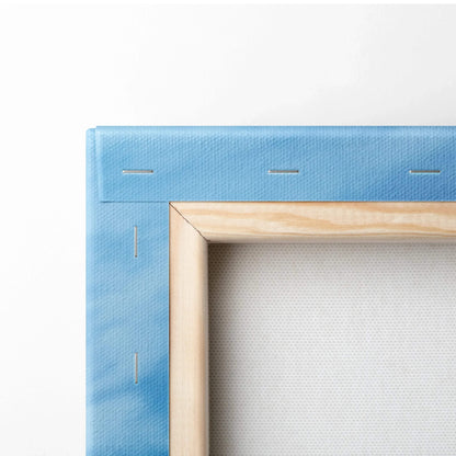 Close-up of blue canvas stretched over wooden frame showing corner stapling for wall art assembly.