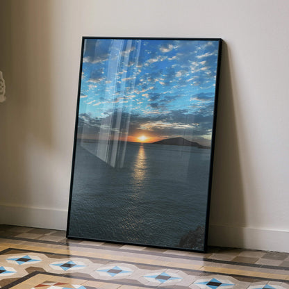 Ocean sunset poster with vibrant sky and water reflection, vertical wall art in black frame.
