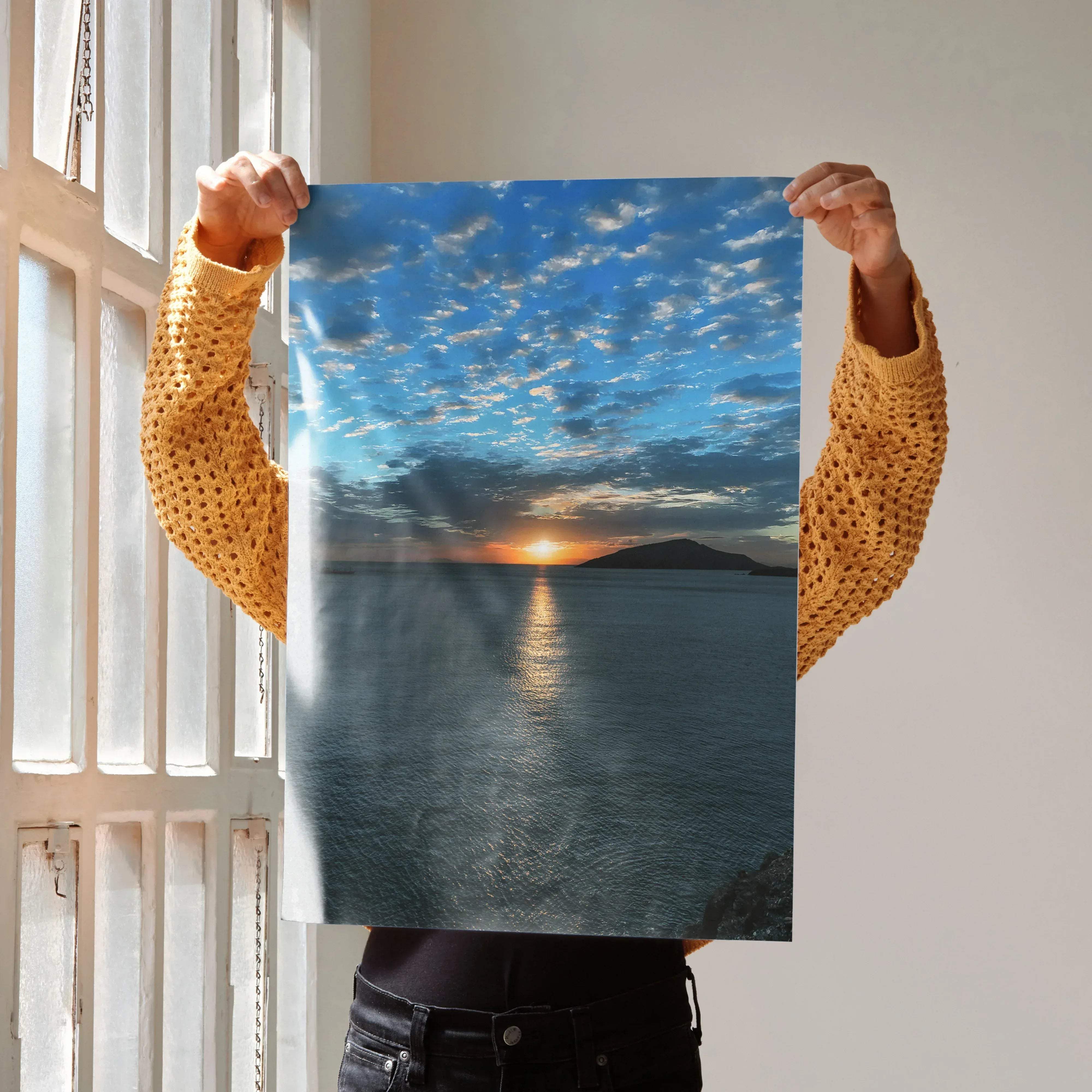 A rectangular breathtaking ocean sunset art print poster showing a serene orange and blue ocean scene held by hands