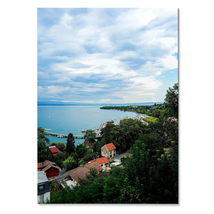 Vertical tranquil nature landscape poster showing a calm lake, cloudy sky, houses, and lush greenery wall art.