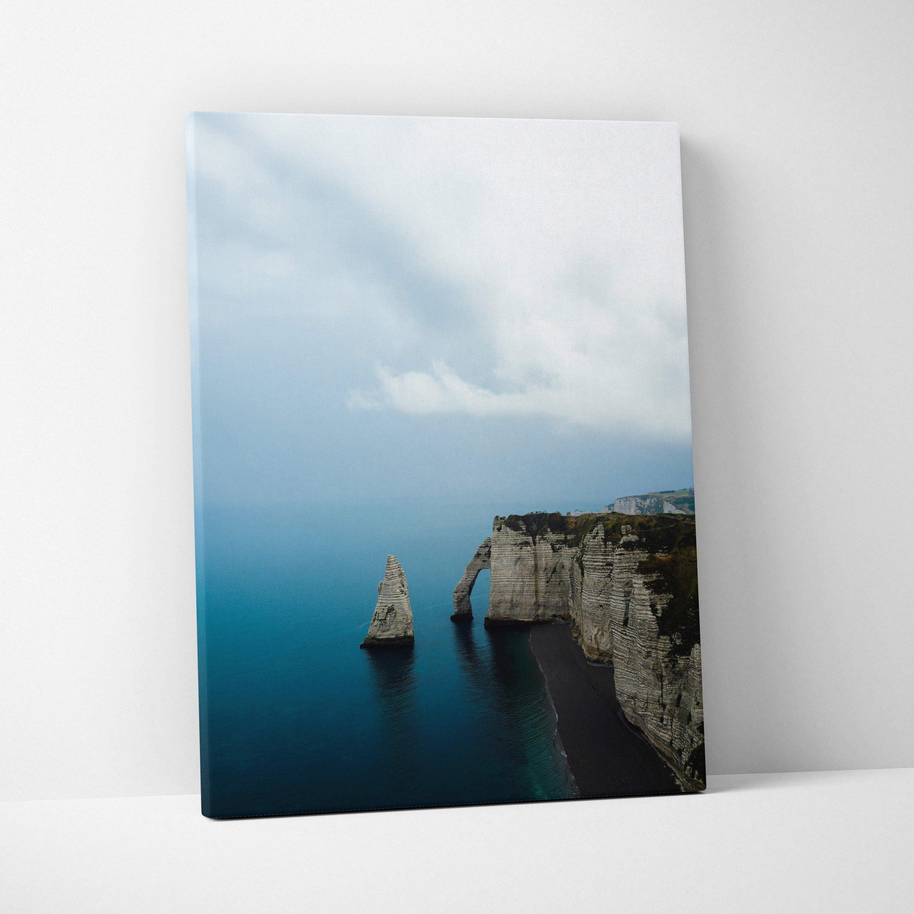 Canvas wall art featuring majestic cliffs and a serene beach under cloudy sky.