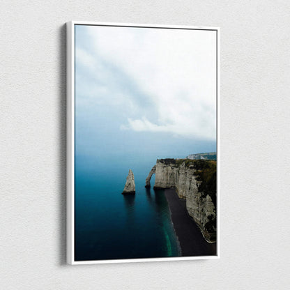 Vertical canvas wall art featuring majestic cliffs and a solitary rock in serene blue ocean under a cloudy sky.