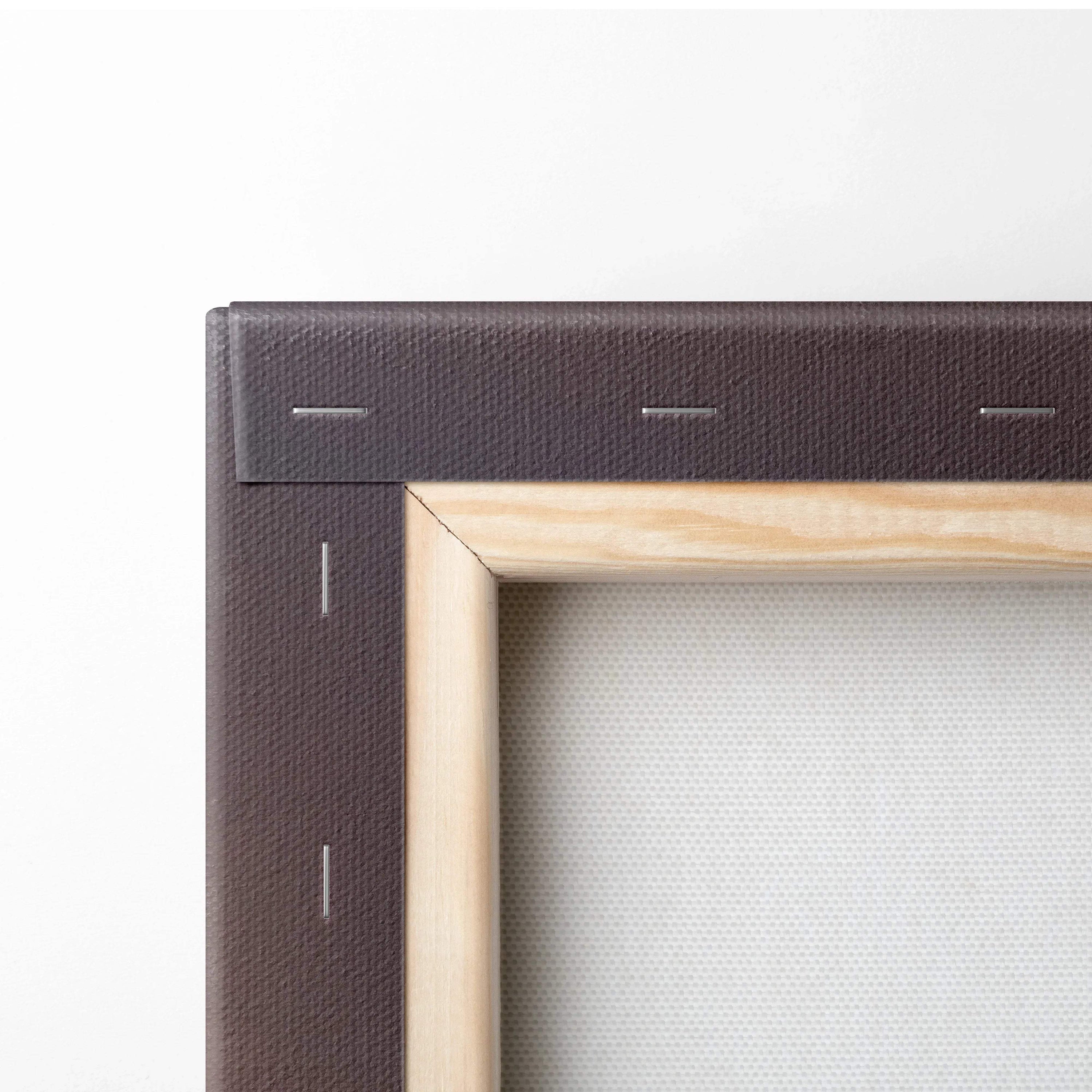 Close-up of wooden frame and brown canvas backing with staples on vertical wall art canvas.