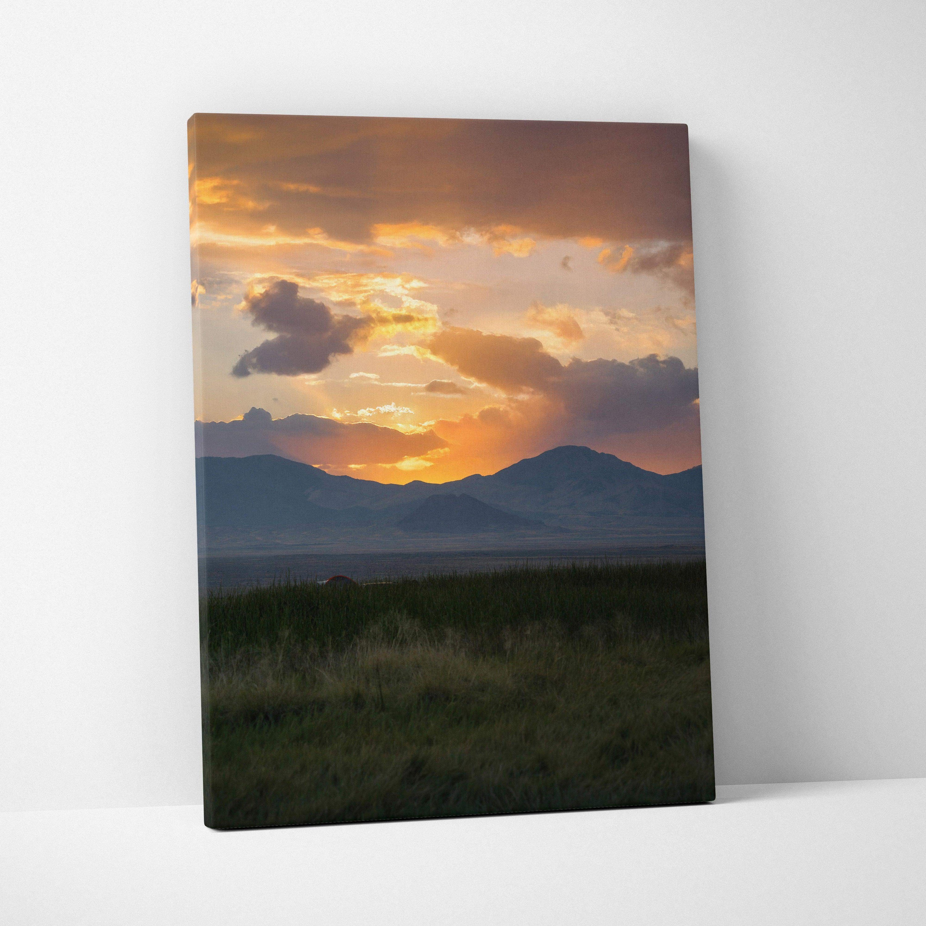 Mountain sunset with glowing orange sky over dark hills canvas wall art.