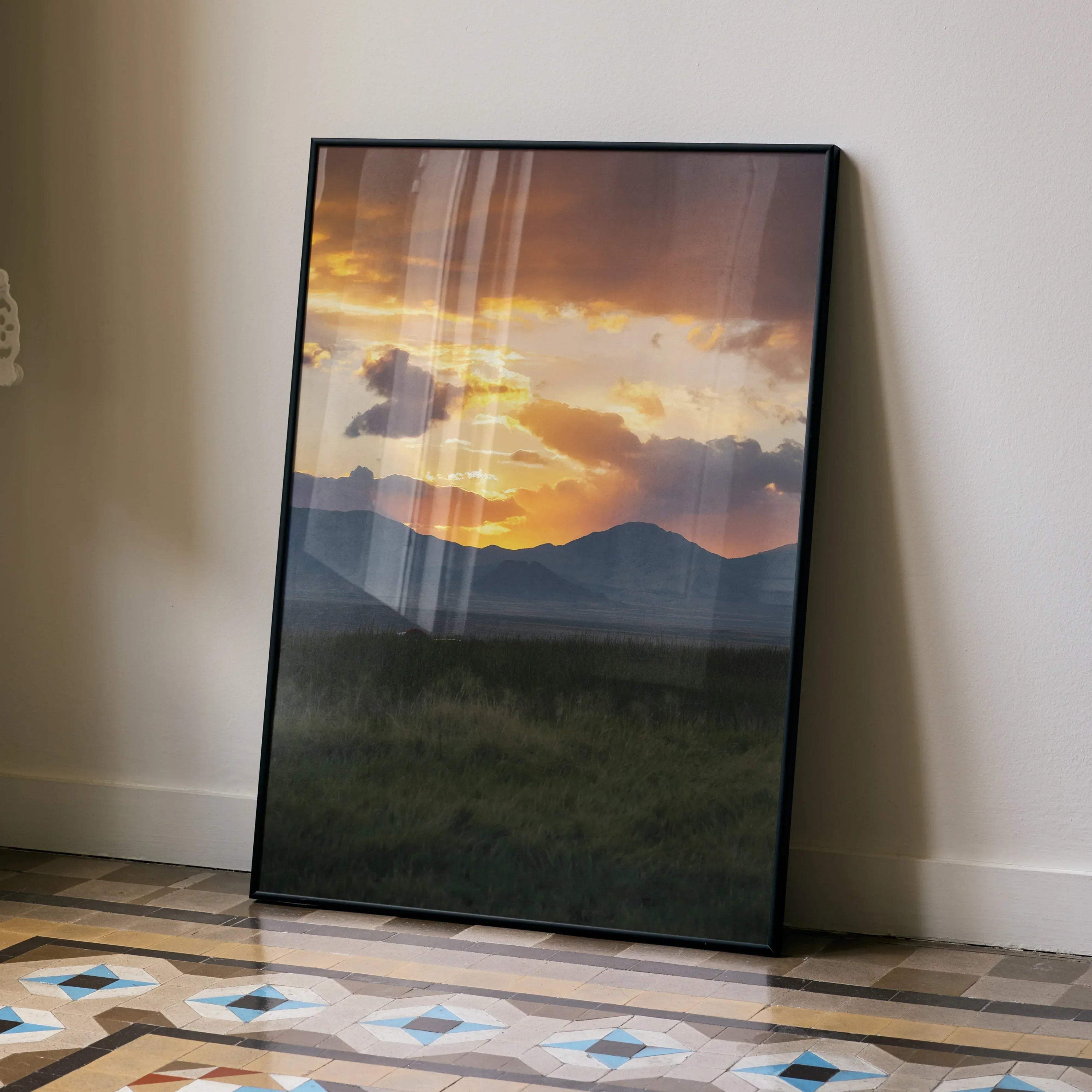 Majestic mountain sunset poster with vibrant orange sky and dark silhouette hills wall art.