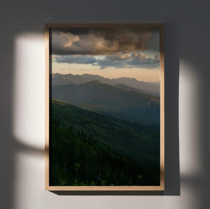 Mountain sunset poster with layered peaks and dramatic clouds, vertical wall art.