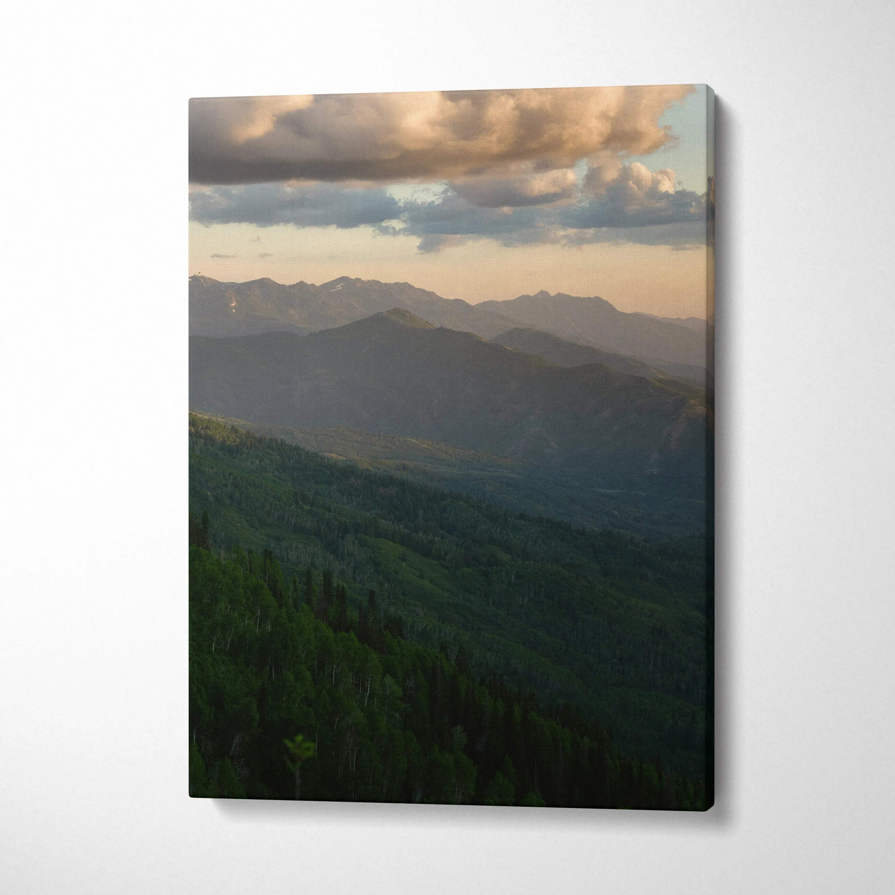 Vertical canvas wall art of a mountain landscape at sunset with layered hills and cloudy sky.
