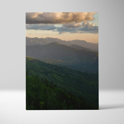 Canvas wall art featuring a majestic mountain range at sunset with soft clouds above.