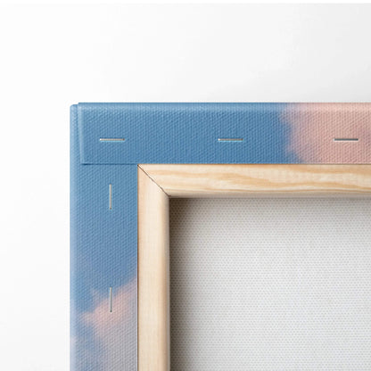 Close-up of wooden frame corner on blue and pink canvas wall art with visible staples.