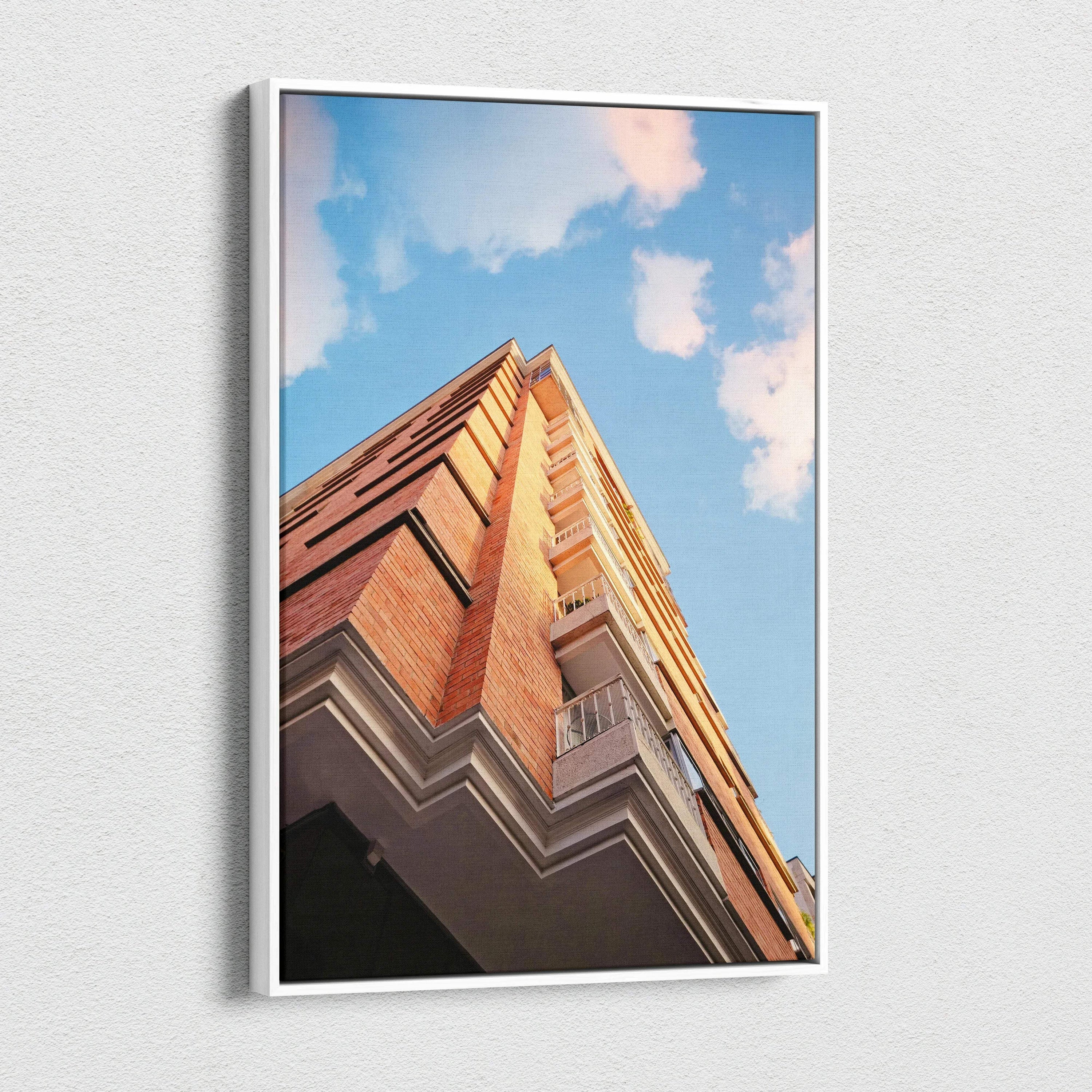 Vertical canvas wall art featuring stunning red brick urban architecture against a blue sky with clouds.
