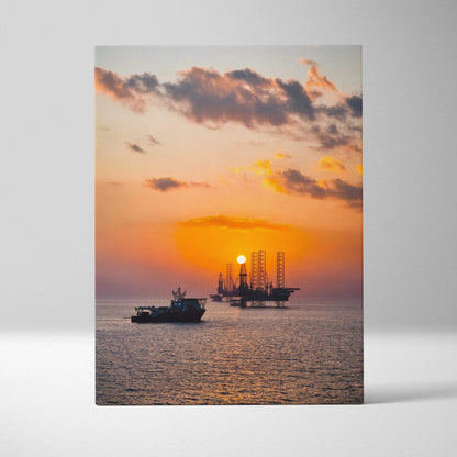 Canvas wall art of vibrant ocean sunset with boat and offshore oil rig silhouette.