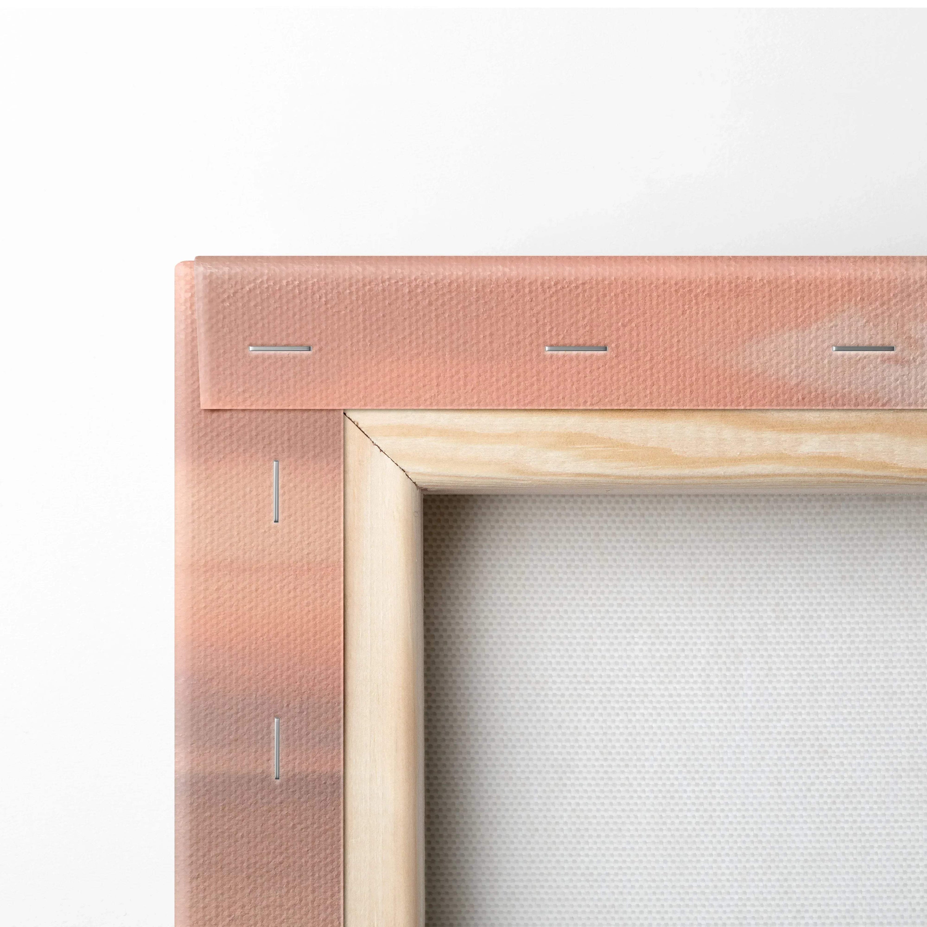 Close-up of wooden stretcher frame and canvas corner with pink and peach tones on wall art.