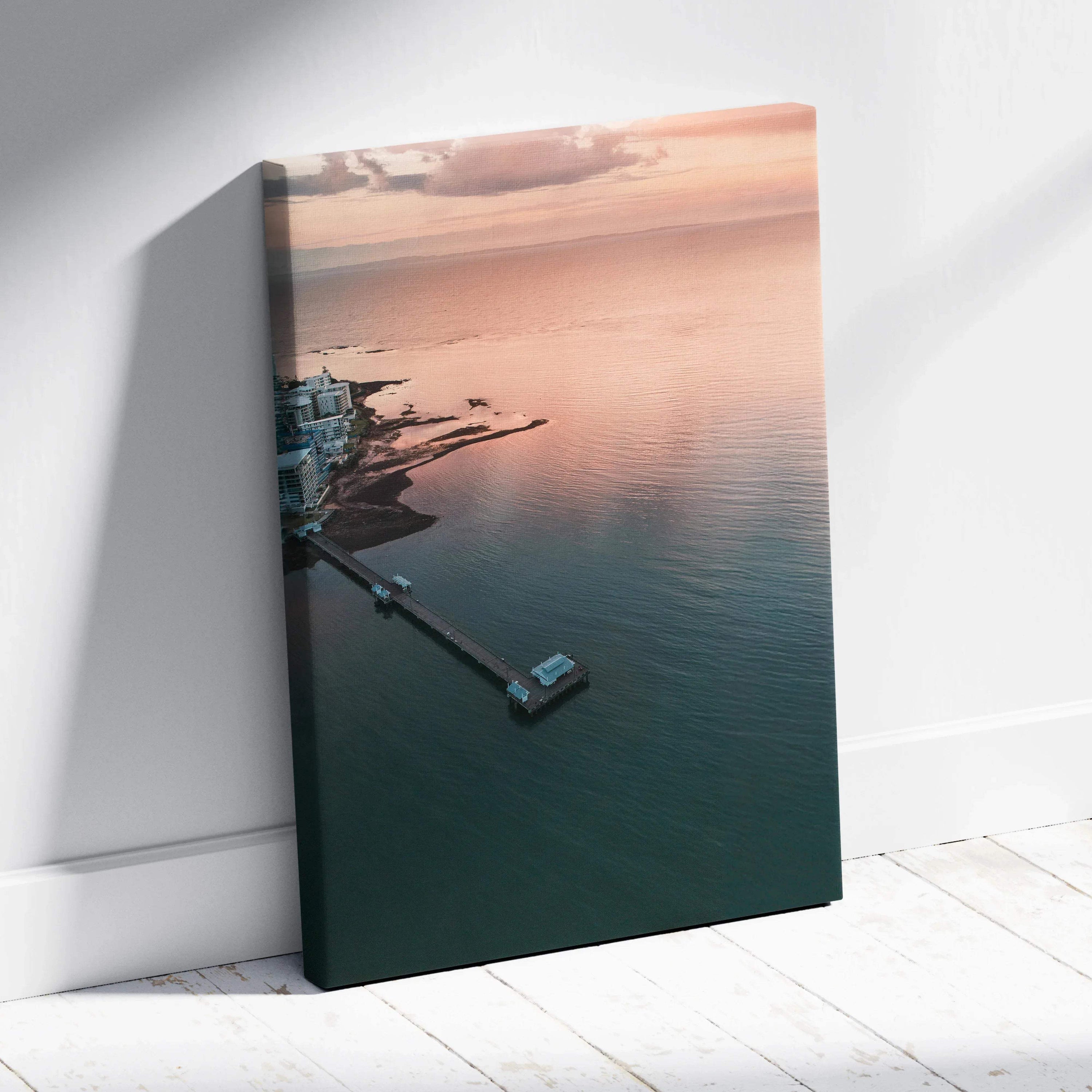 Ocean sunset over calm water with pier, vertical canvas wall art with soft pink and blue tones.