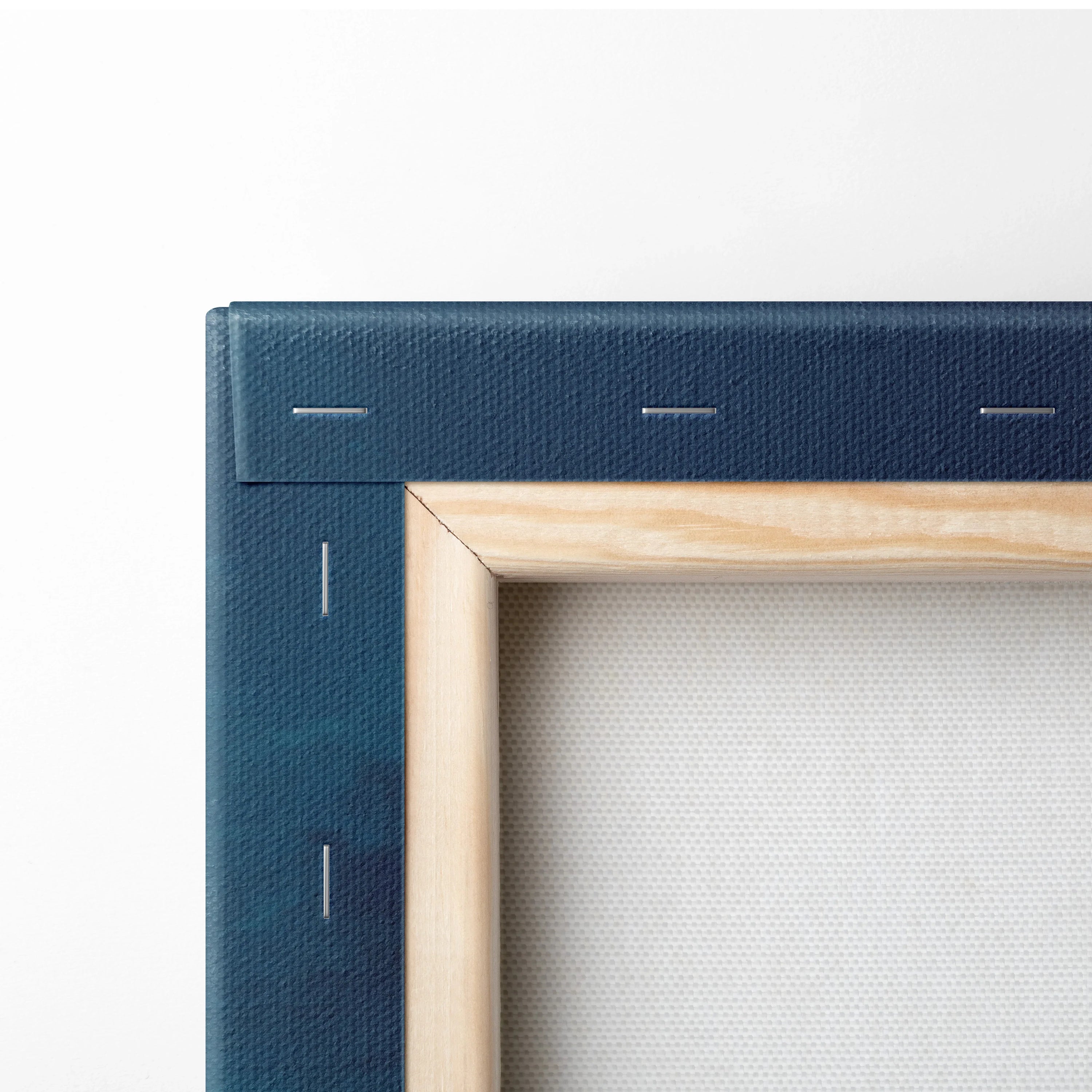 Close-up of wooden frame back and blue canvas fabric with metal staples on wall art canvas.