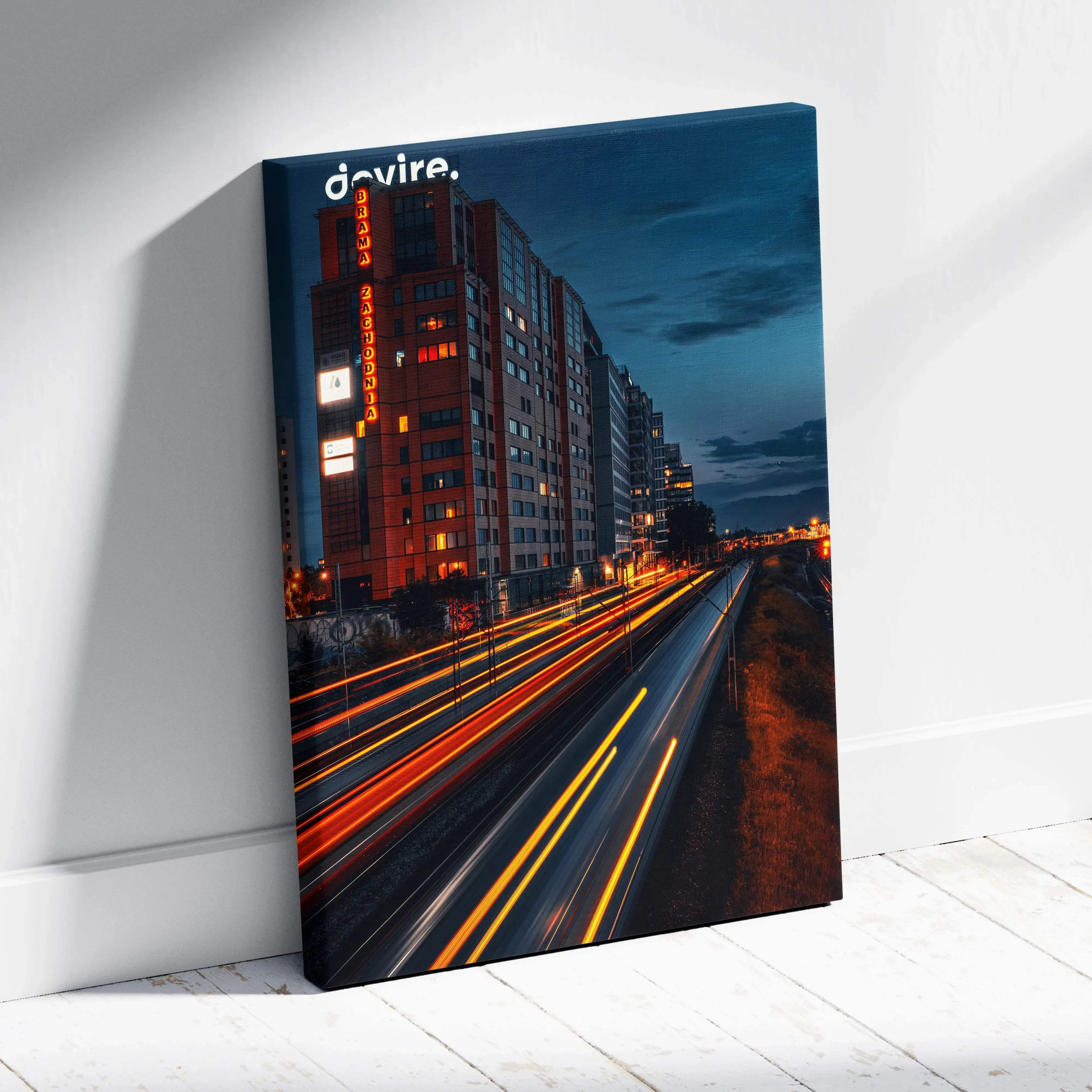 Urban night cityscape canvas wall art featuring a red brick building with neon light trails and warm vibrant glow displayed on white wall