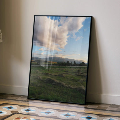 Vertical poster wall art featuring a mountain sunset with vibrant clouds over green fields.