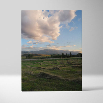 Vertical canvas wall art featuring a serene mountain landscape under a dramatic cloudy sunset sky.