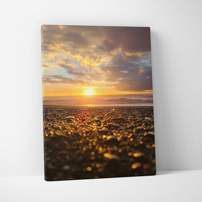 Canvas wall art featuring a glowing golden beach sunset with textured pebbles in foreground.
