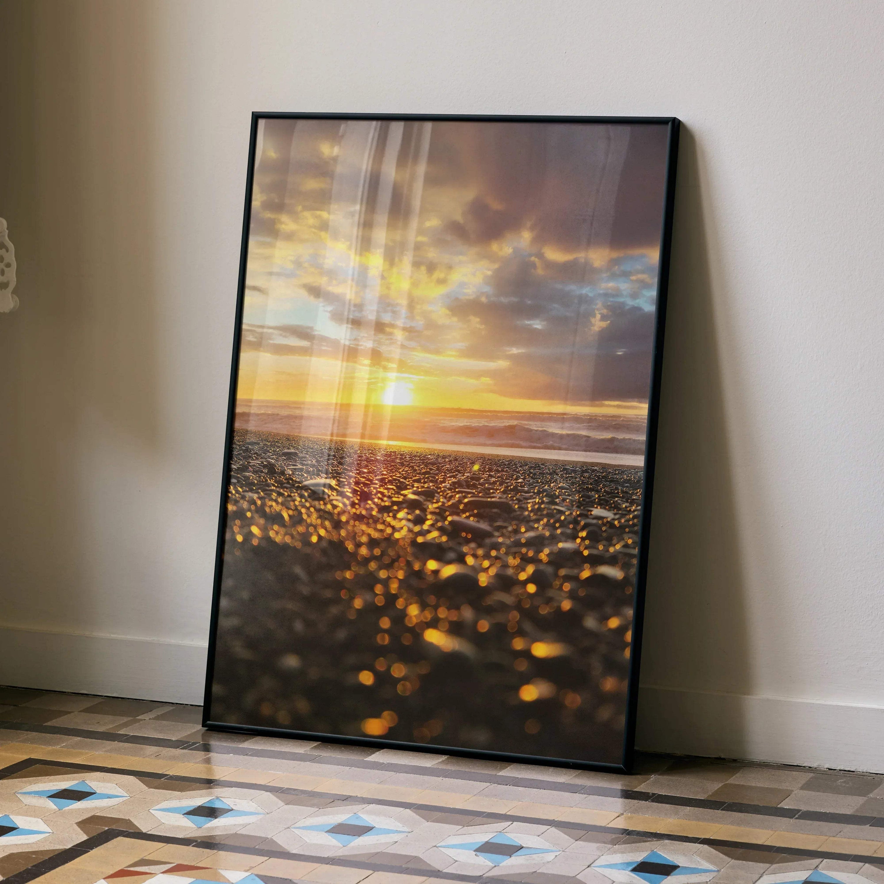 Ocean sunset beach poster with golden sunlight and dark clouds, vertical wall art in black frame.