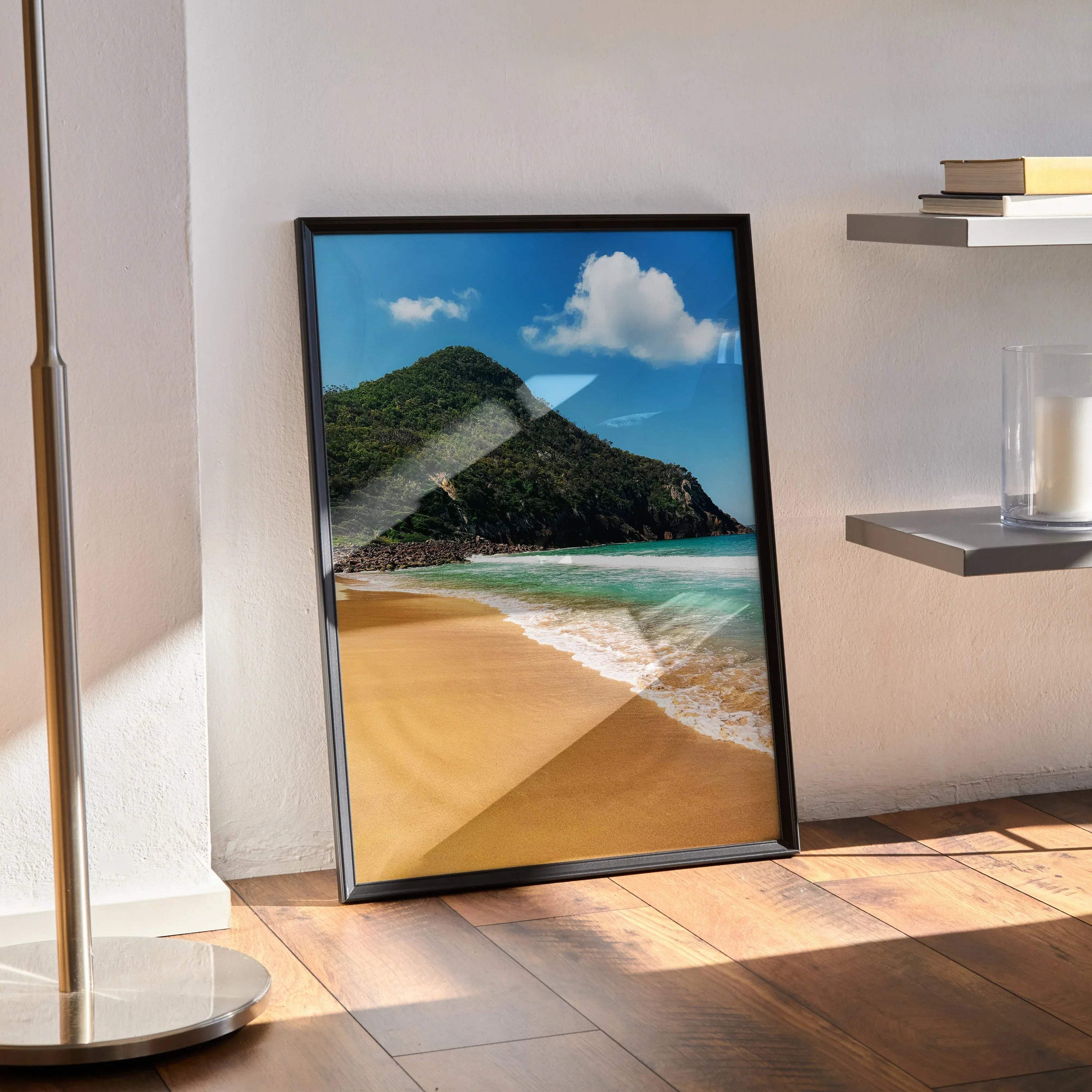 Serene beach poster with ocean waves, sandy shore, and blue sky wall art in black frame.