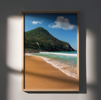 Serene beach wall art poster featuring sandy shore, turquoise ocean waves, and green hillside under blue sky.